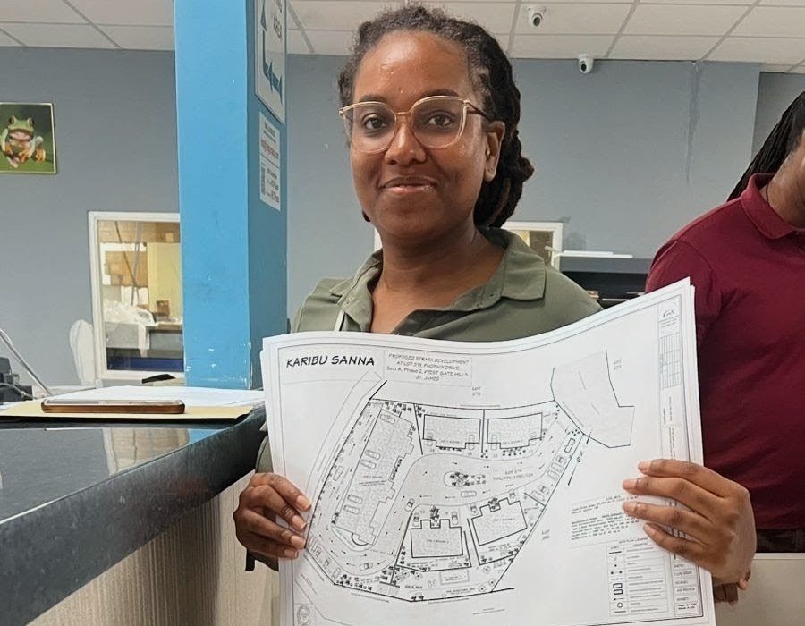 Violet Palmer holding the Karibu site plan at the St. James Municipal Corporation during submission